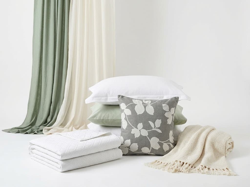 Sage linen curtains with white pillows, gray leaf cushion and cream fringed throw