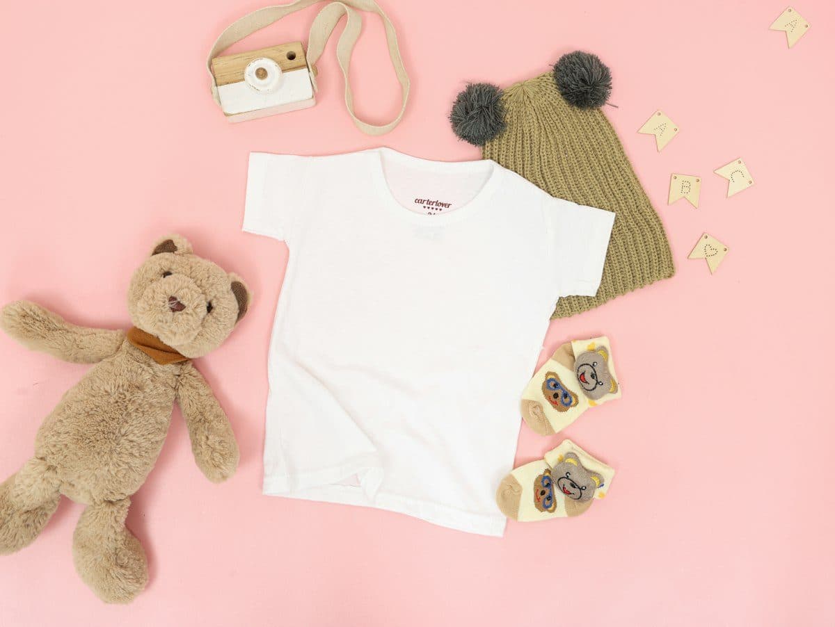 Children's white t-shirt flat lay with toys