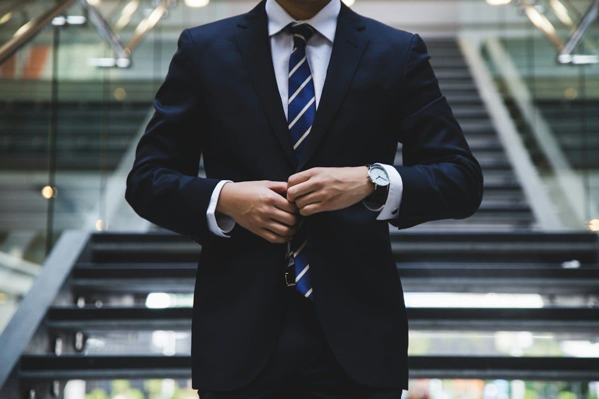 Man adjusting a tailored navy suit